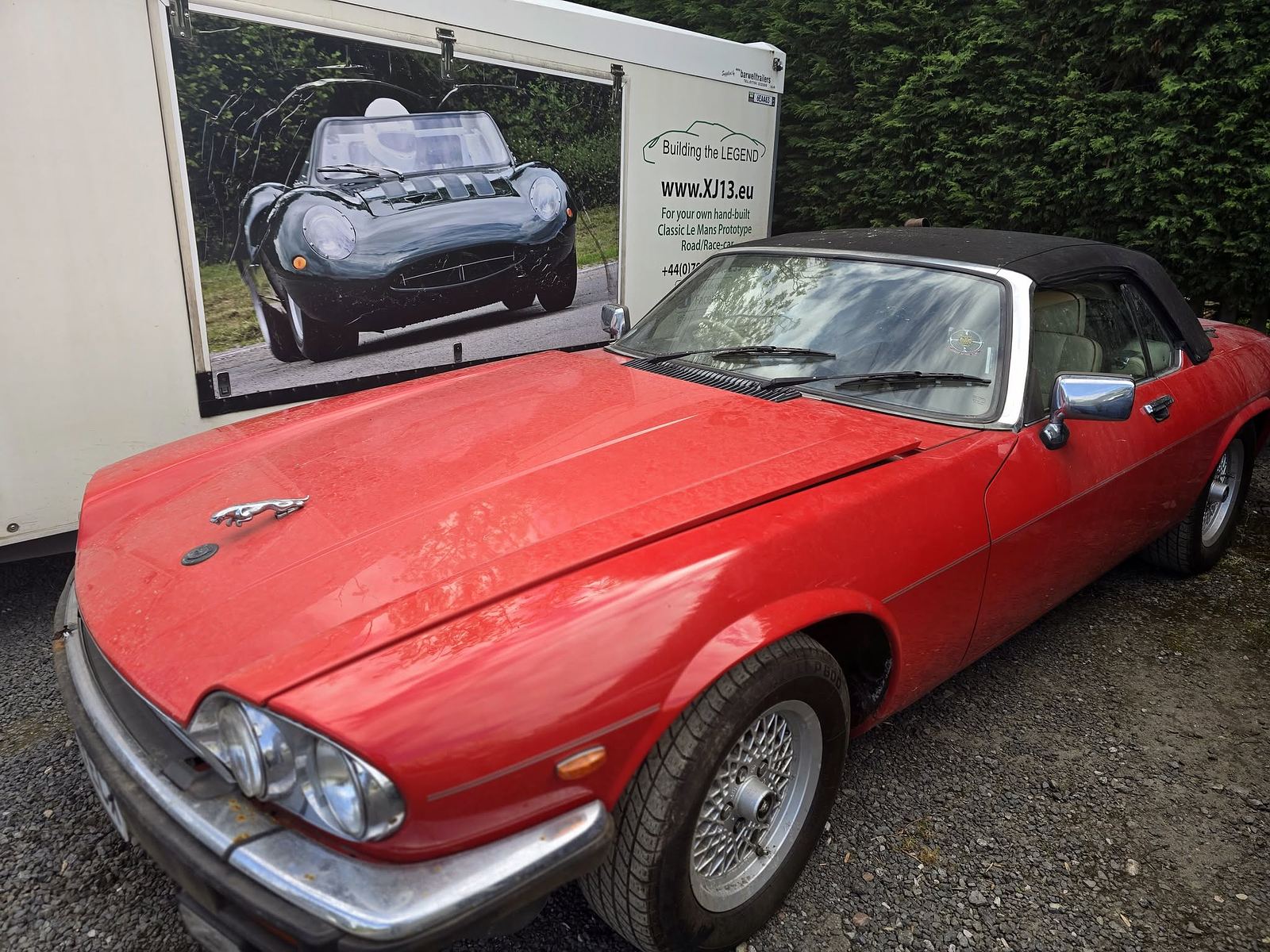A red Jaguar XJS convertible outdoors ready to go home