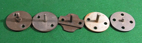 Five sprockets: early two-bolt types at left, the scalloped two-bolt sprocket to avoid in the middle, four-bolt locking-plate types at right — the far-right one is the V12 sprocket